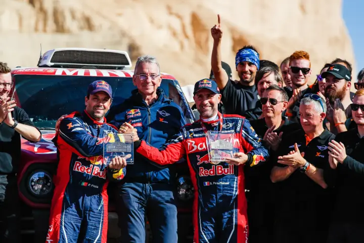 Dakar Rally 2020: drivers and team celebrating holding trophies at finish