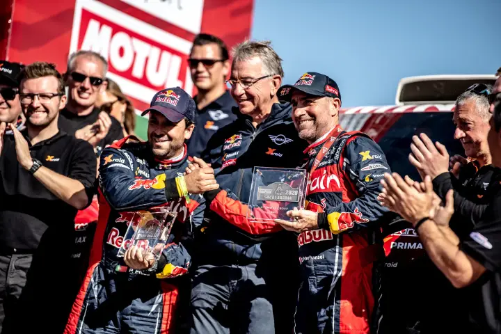 Dakar Rally 2020: drivers and team principal holding Dakar trophy together