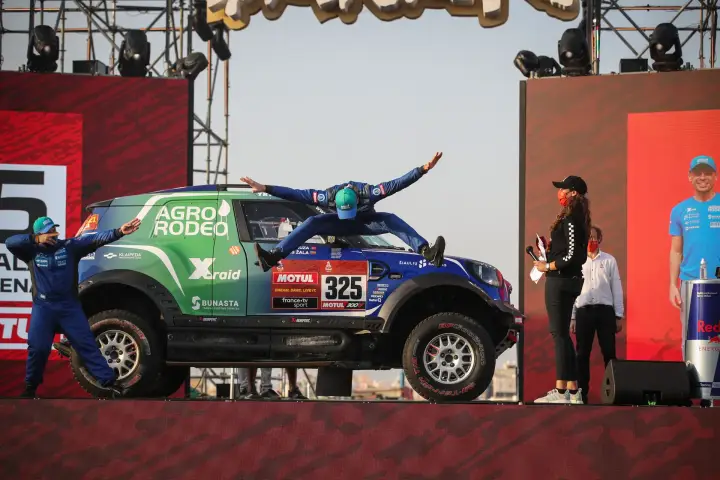 Dakar Rally 2021: driver jumping on car roof at Dakar podium stage