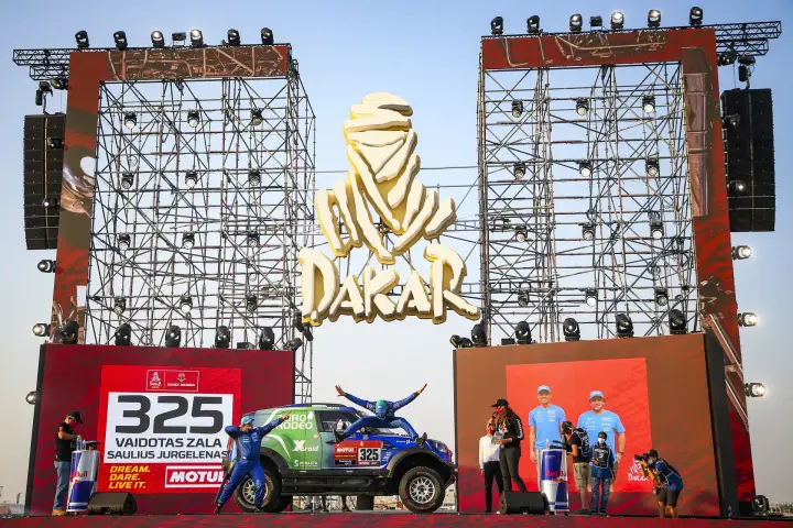 Pódio: car and team under golden Dakar logo podium stage