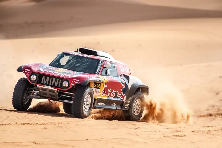 Riyadh Rally 2019: red Mini JCW cornering through Saudi Arabian sand dunes